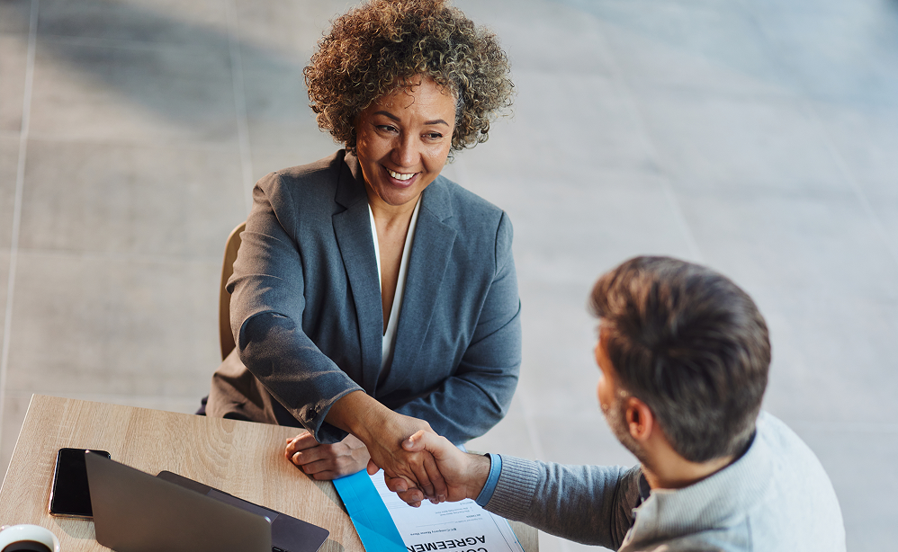 Two professionals shaking hands during a business meeting.