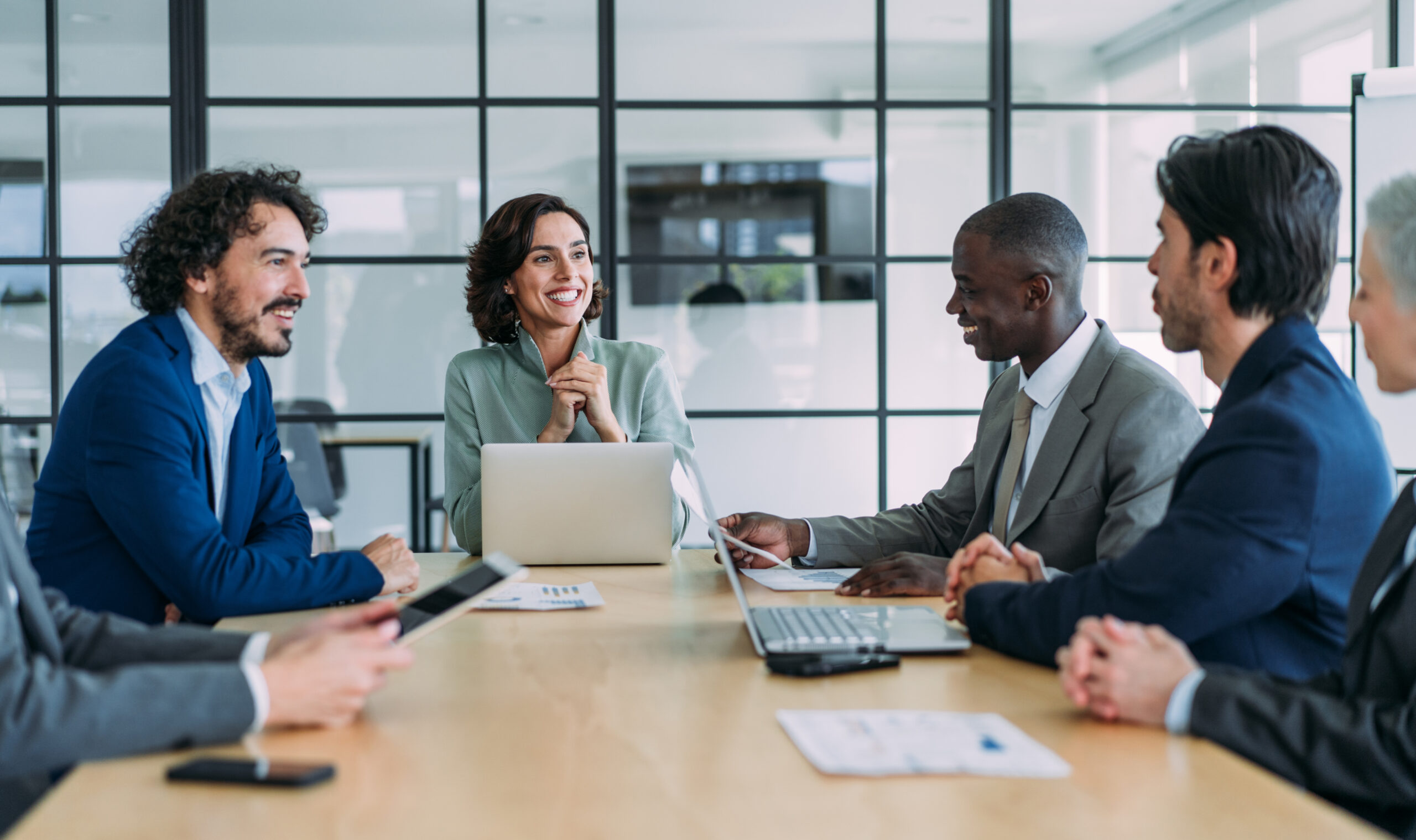 Four professionals engaged in a collaborative business meeting around a conference table.