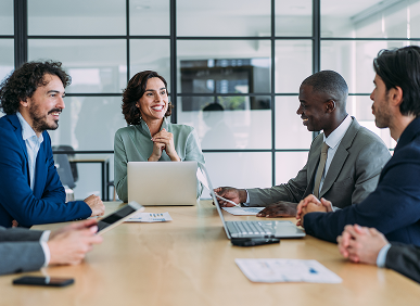 A diverse group of professionals discussing around a conference table.